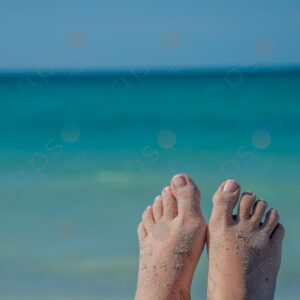 Pale-skinned woman's feet with sand