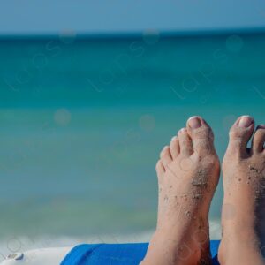 Pale-skinned woman's feet with sand