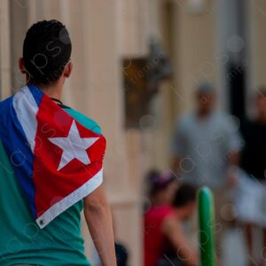 Young man carries a Cuban flag on his back