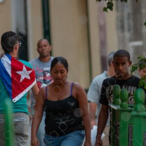 Young man carries a Cuban flag on his back