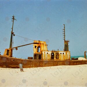 Abandoned boat on Saint-Louis beach and Senegalese man