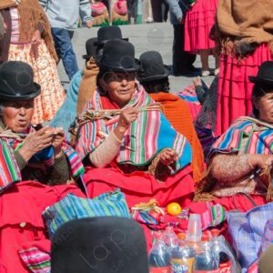 Three Cholitas are seated enjoying their snacks La Paz Bolivia