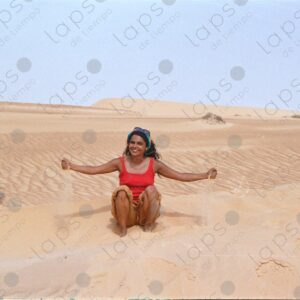 Woman plays with sand in the desert