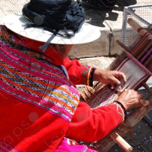 A woman in traditional indigenous attire weaving on a loom 5