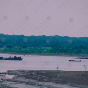 Backlit landscape, boat and ship passing by