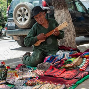 Bolivian Man with Charango Ambulant Seller of Textiles 1