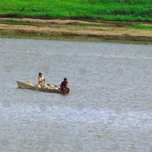 Canoe loaded with sacks and two men on the river
