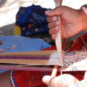Detail of hands with bone weaving on a loom 1