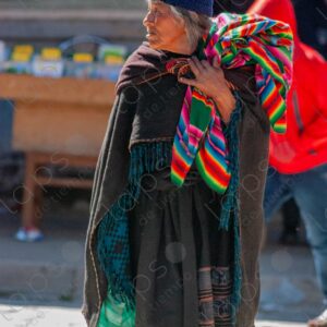 Elderly indigenous woman wearing textiles and carrying an aguayo
