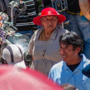 Elderly woman with a red hat among the crowd