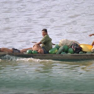 Family in a canoe loaded with watermelons