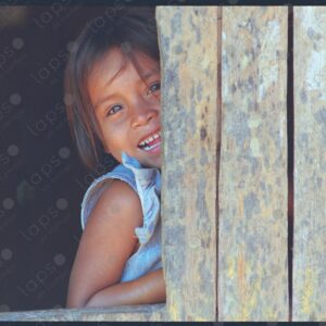 Girl smiles at the camera from her window
