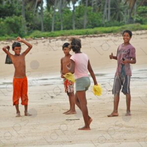 Group of teenagers standing on sand looking at camera 2