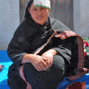 Indigenous woman dressed in black and decorated hat