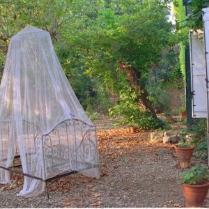 Iron bed with mosquito net in the garden