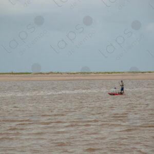 Landscape of a river with two men on a raft