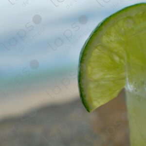 Lemon detail in caipirinha glass with beach landscape 2