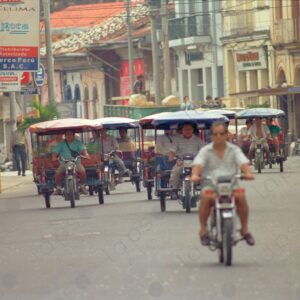 Motorcars approach the camera on the avenue