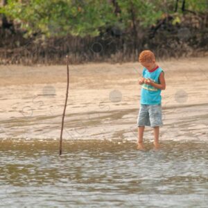 Redhaired boy by the riverside