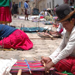 Several weavers on the floor with their looms weaving 3
