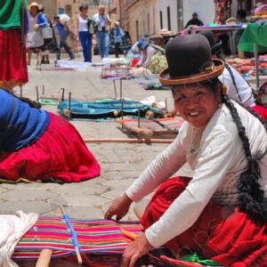 Several weavers on the floor with their looms