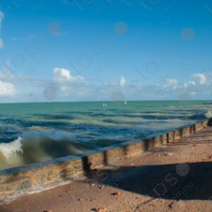The turquoise sea crashes against the cement shore 2