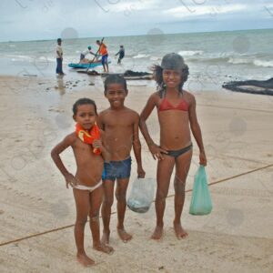 Three brothers in swimsuits posing for the camera on the seashore 1