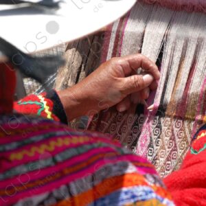 Woman in traditional indigenous attire weaving on a loom 2