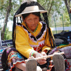Indigenous old woman weaves with a foot loom 1