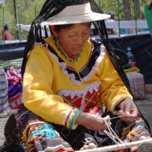 Indigenous old woman weaves with a foot loom 2