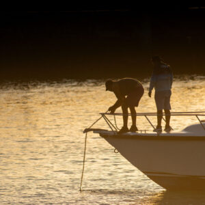 people at harbor with anchor in backlight 1
