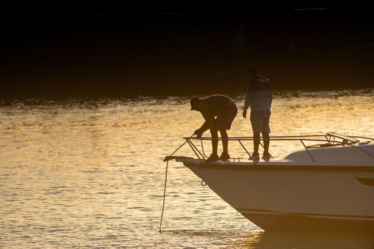 people at harbor with anchor in backlight 1