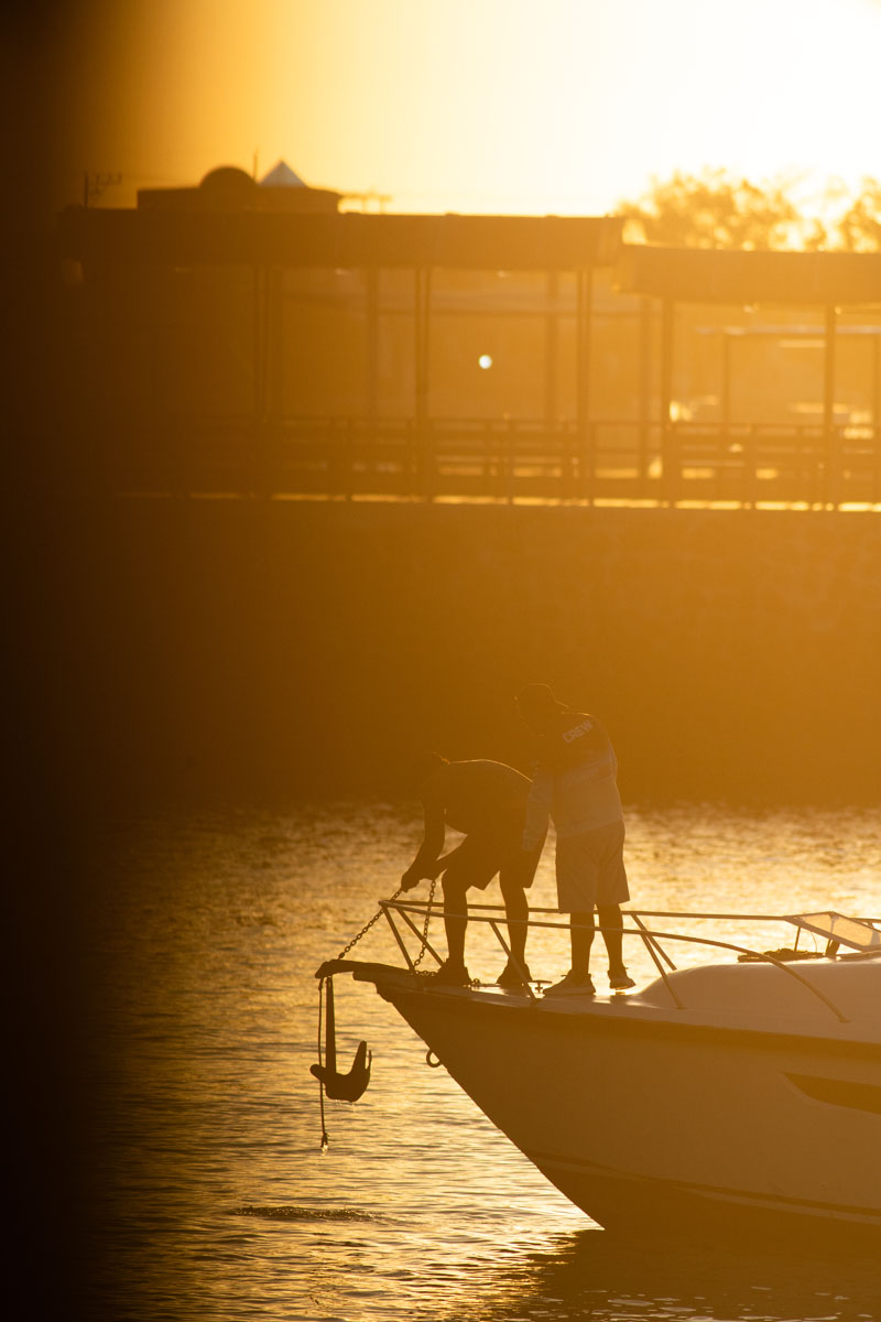 people at harbor with anchor in backlight 4