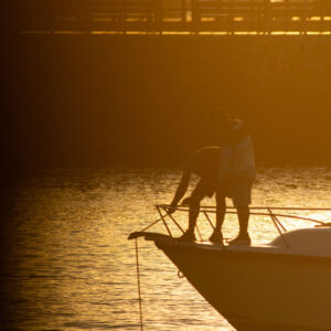 people at harbor with anchor in backlight 5