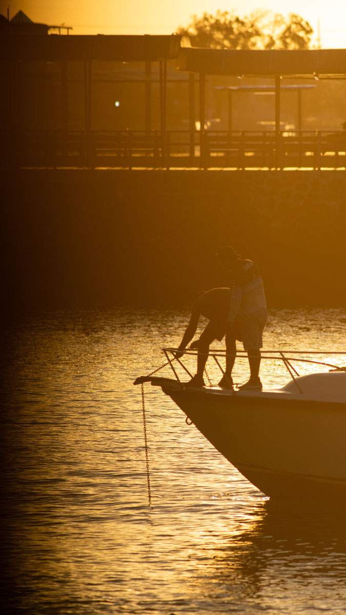 people at harbor with anchor in backlight 5