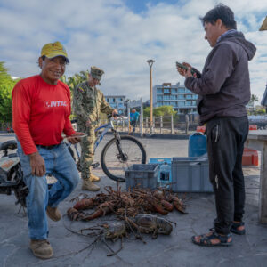 smiling man selling lobster at the pier