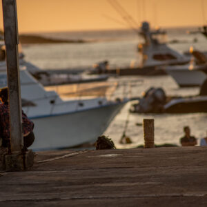 women sitting on pier at sunset 2