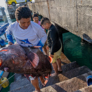 young people on pier receiving catch 18