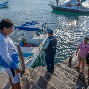 young people on pier receiving catch 2