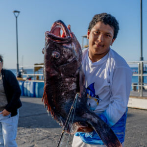young people on pier receiving catch 30