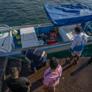 young people on pier receiving catch 3