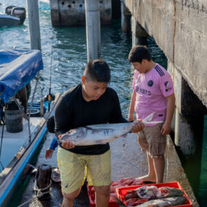 young people on pier receiving catch 7