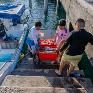 young people on pier receiving catch 9