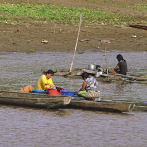 on the riverbank women wash clothes