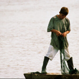 young man untangles a fishing net